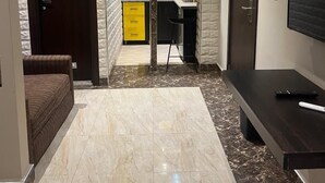 A modern kitchen with a yellow cabinet, a black countertop, and a sink. - Citistay Apartments (Abuja)