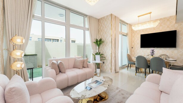Ein geräumiges Wohnzimmer mit großem Fenster, Flachbildfernseher, Essbereich und einer modernen Kronleuchter.