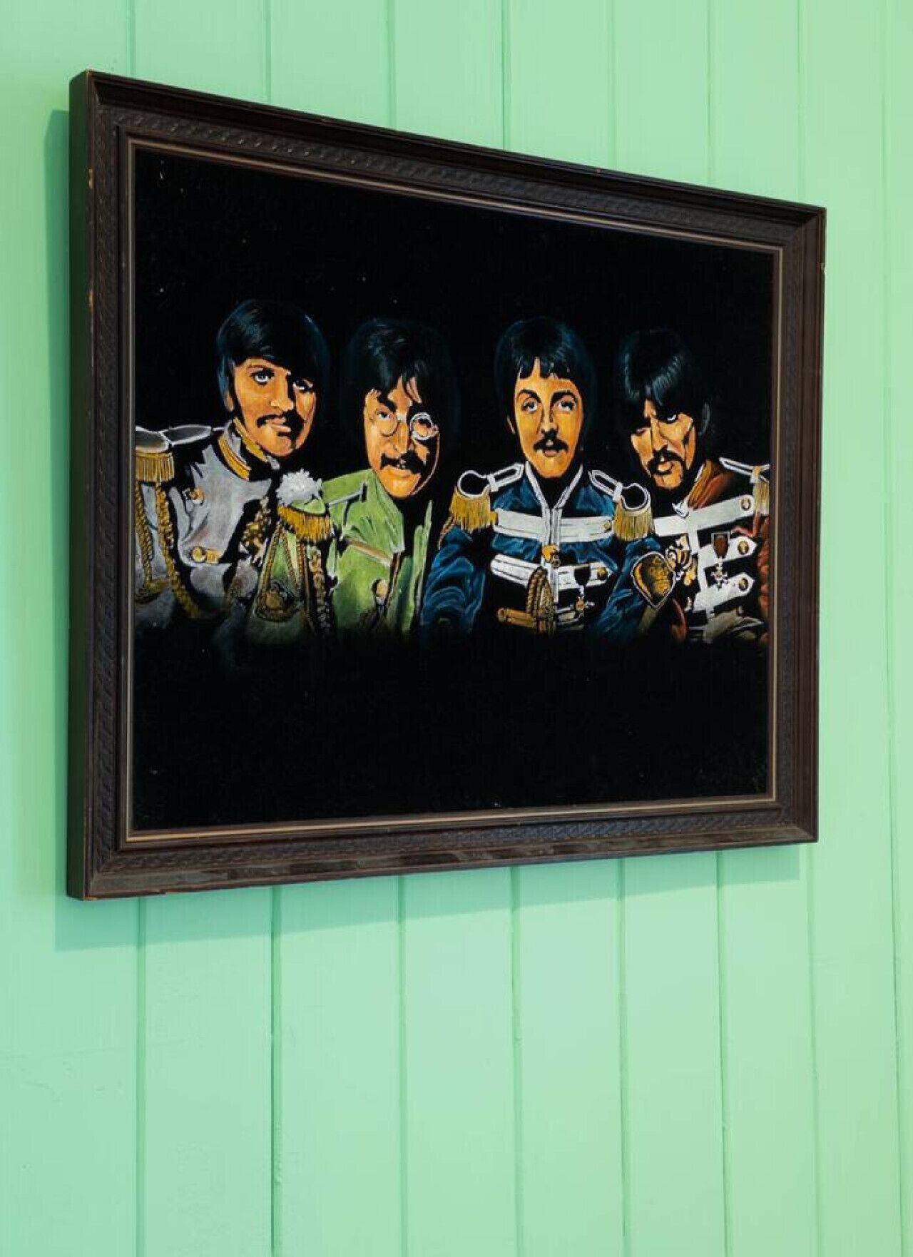 Ein gerahmtes Kunstwerk zeigt vier Personen in Uniform an einer grünen Wand.