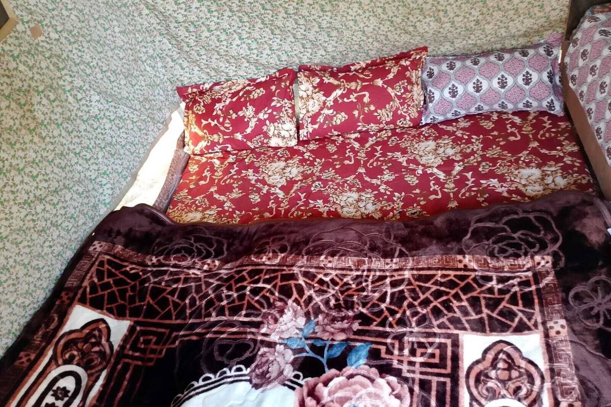 A bed with a floral-patterned bedspread and two pillows with different patterns.