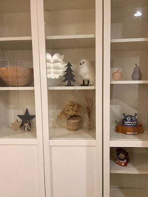 A room with a white cabinet containing various decorative items.