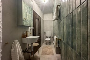 A bathroom with a sink, toilet, and towel rack.