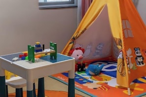 A play area with a table, toys, and a tent. - Tai'an Mingzuo Santai Theme Hotel (Taishan Scenic Area) (Tai'an)