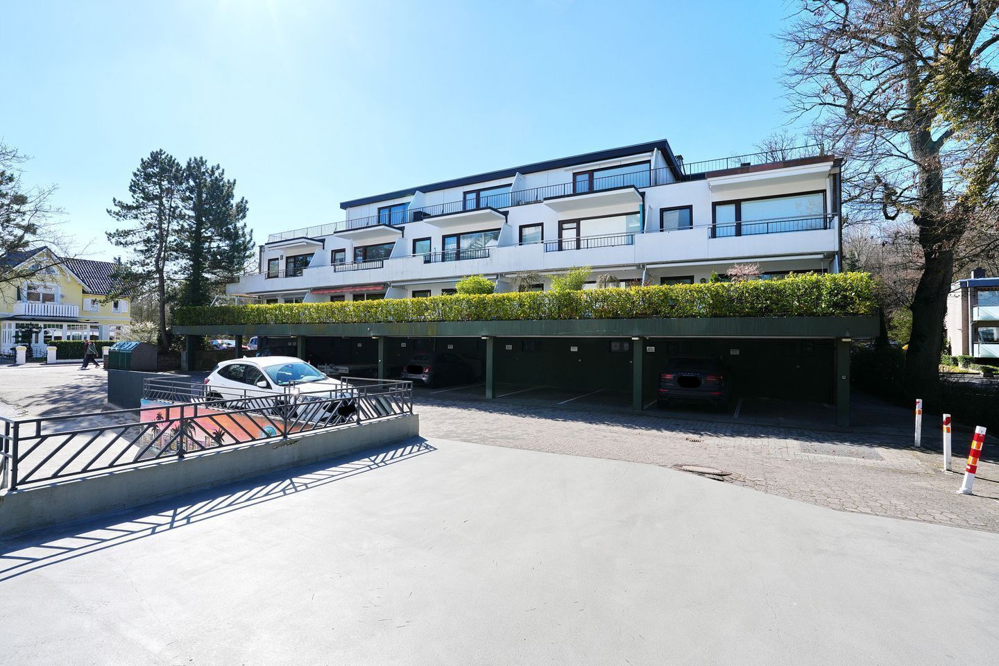 En byggnad med flera våningar och en parkeringsplats framför.