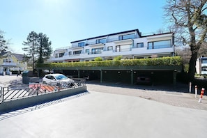 A multi-story building with a parking area in front.