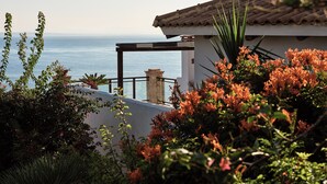 A coastal building with a tiled roof, a balcony with a railing, and a view of the sea. - Villa Yiannis - Sea View & Private Pool (Zakynthos)