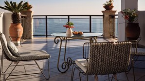 A terrace with a round table, two chairs, potted plants, and a view of the sea. - Villa Yiannis - Sea View & Private Pool (Zakynthos)