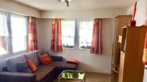 Una sala de estar con sofá, mesa de centro y aparador.