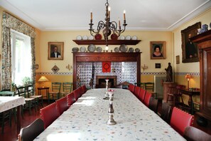 A dining room with a long table, chairs, a chandelier, and a fireplace. - Spacious 11-bed Family Retreat (Ruiselede)