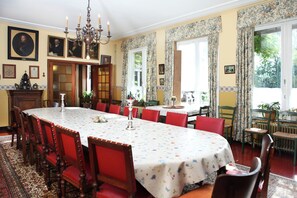 A dining room with a large table, red chairs, and a chandelier. - Spacious 11-bed Family Retreat (Ruiselede)