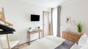 A bedroom with a bed, a desk, a chair, a television, and a wardrobe. - Gemutliche Ferienwohnung, Beilngries (Beilngries)