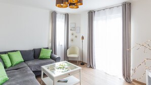 A modern living room with a grey sofa, a glass coffee table, a floor lamp, and a chair. - Gemutliche Ferienwohnung, Beilngries (Beilngries)