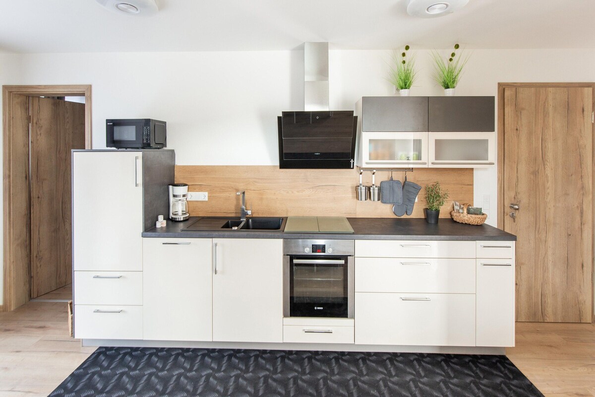 A modern kitchen with a built-in oven, microwave, and coffee maker.