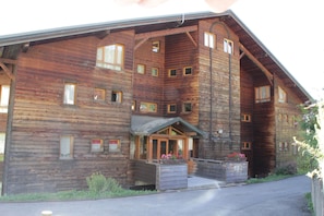 Ein großes Holzgebäude mit vielen Fenstern und einem zentralen Eingang.