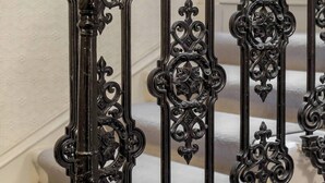 A staircase with ornate black metal railings and a wooden handrail. - 6 on Chester Apartments (Edinburgh)