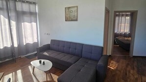 Ein modernes Wohnzimmer mit einer Eckcouch, einem kleinen Couchtisch und einem Bild an der Wand.