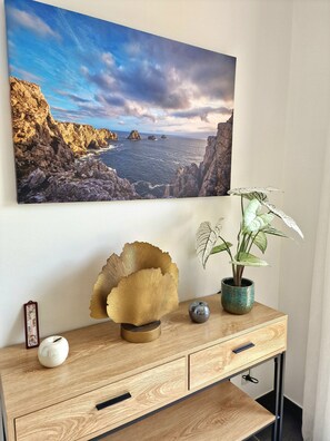 Un bureau en bois orné d’un bol décoratif, d’une plante en pot et d’un petit objet sphérique.