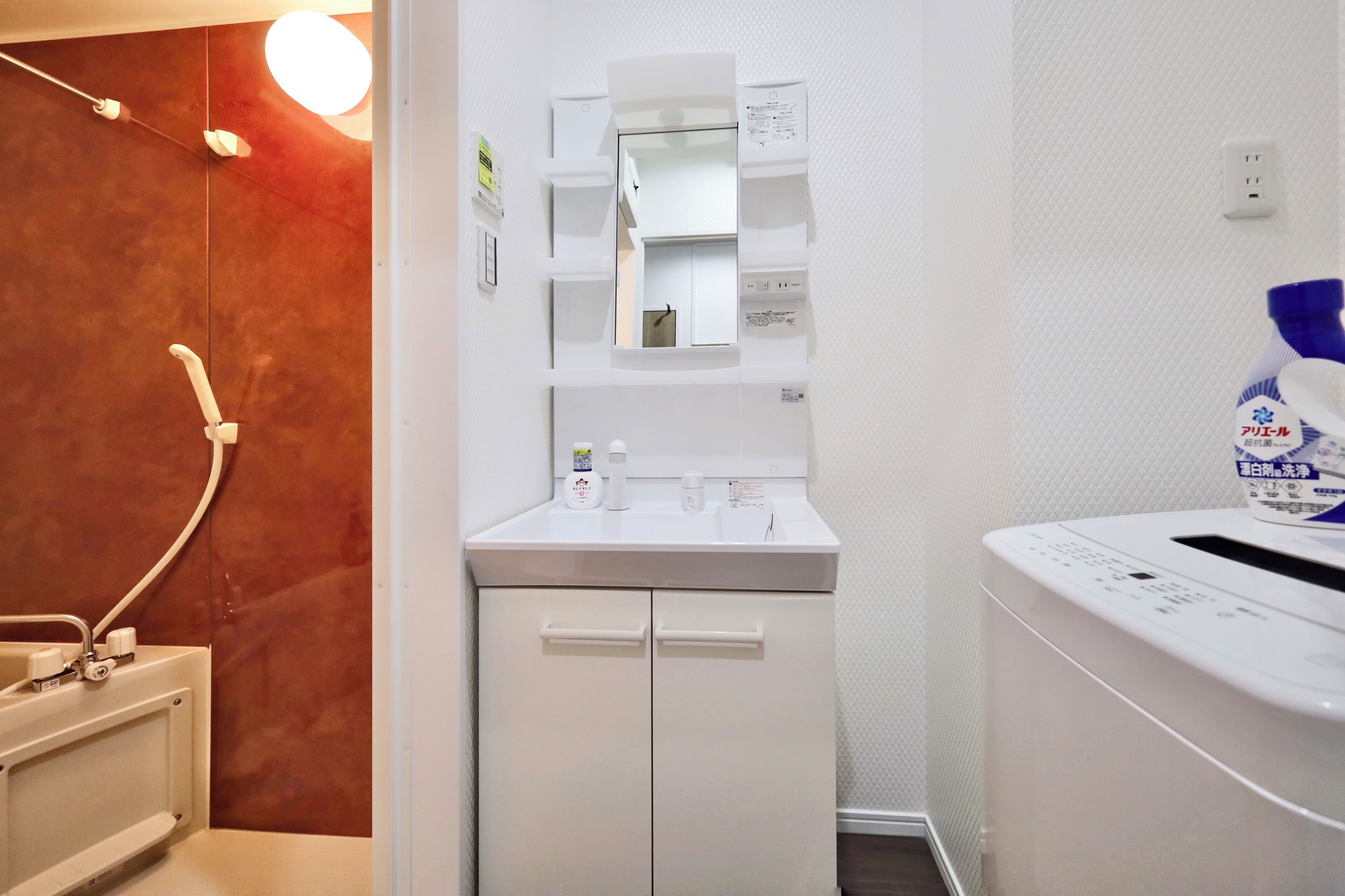 A bathroom with a white sink, mirror, and towel rack.