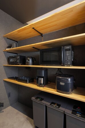 A kitchenette with wooden shelves, a microwave, a coffee maker, and a toaster. - U suzukou (Asahikawa)
