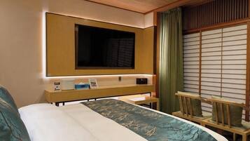 A hotel room with a bed, a bedside table with a lamp, a TV mounted above the bed, and a sliding shoji screen door.