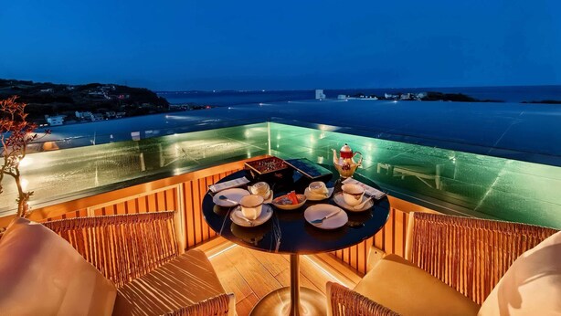 A rooftop terrace with a table set for tea, overlooking a body of water and distant land. - Tsuruyoshikawa onsen hotel (Manazuru)
