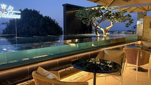 A modern outdoor seating area with a glass balustrade overlooking a body of water and a distant island. - Tsuruyoshikawa onsen hotel (Manazuru)