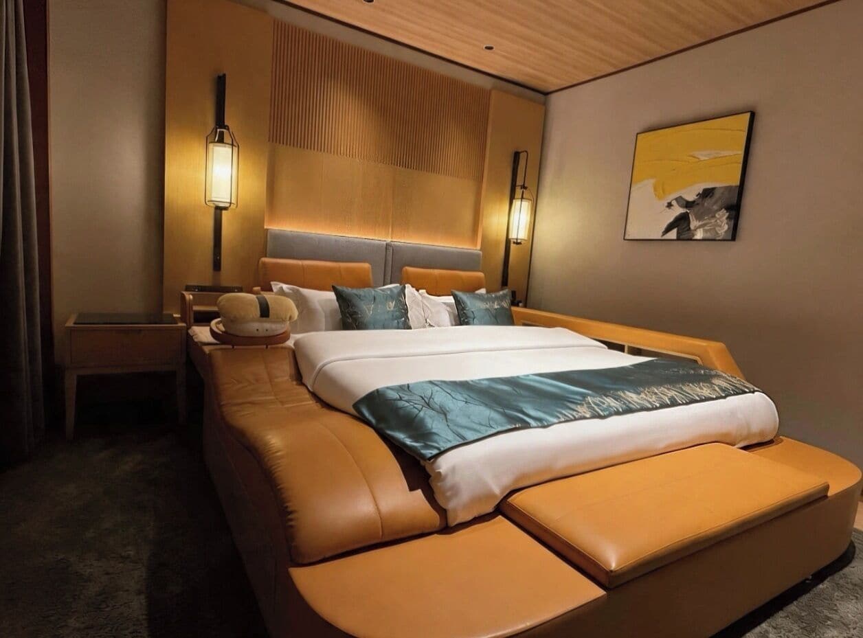 Une chambre d’hôtel avec un grand lit, une table de chevet, une lampe et un tableau au mur.