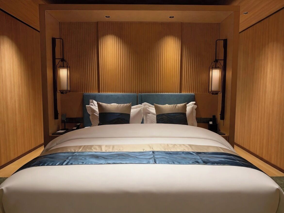 Een hotelkamer met een groot bed, twee bedlampen en houten lambrisering.