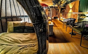 Ein Zimmer mit einem Bett, einer Bank und einem kleinen Tisch.