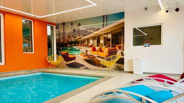 Una piscina interior amb gandules, un mural i un disseny d'interior modern.
