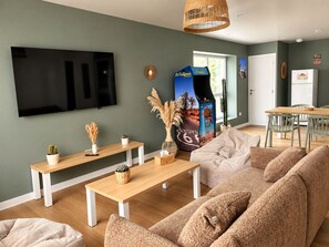 A modern living room with a flat-screen TV, wooden furniture, and a Route 66 themed wall decoration.