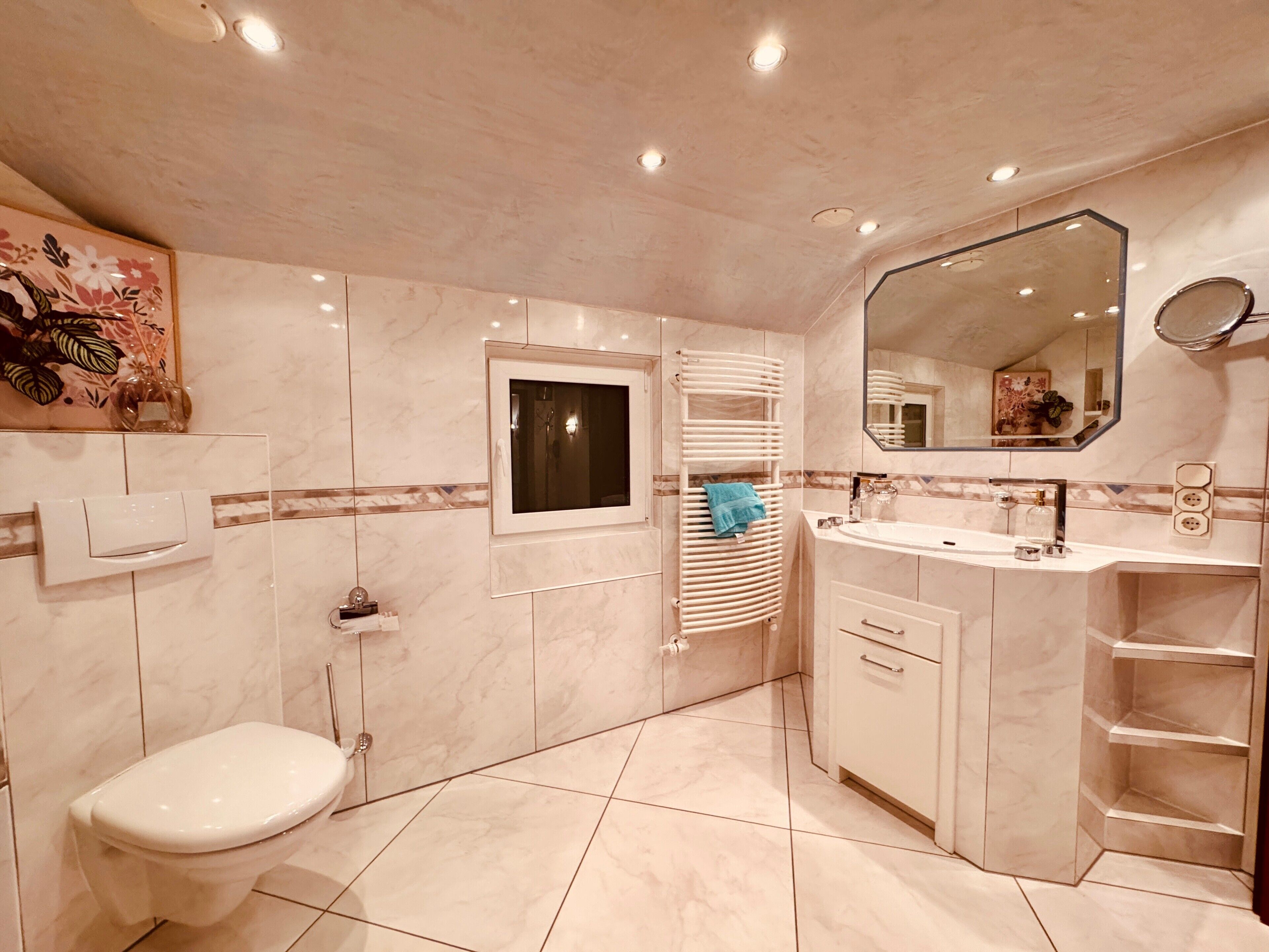 A modern bathroom with a toilet, a sink, a mirror, and a towel rack.