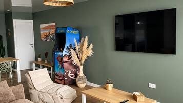 Ein Wohnzimmer mit Sofa, Couchtisch, Fernseher und Bücherregal.