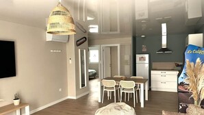 Un saló modern amb zona de menjador, cuina i una finestra gran.