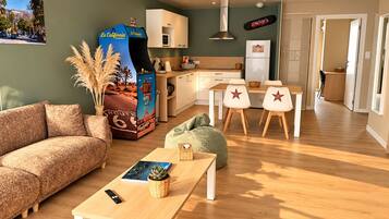 En moderne stue med sofa, sofabord og et spiseområde med stole.