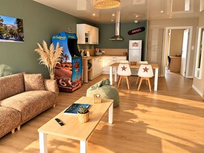 Un salon moderne comprenant un canapé, une table basse et un coin repas avec des chaises.