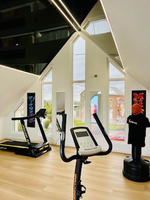 A modern gym with two exercise bikes, a treadmill, and a mannequin. - ⭐ Hollywood Suite - Suite in residence with swimming pool (Neuf-Mesnil)