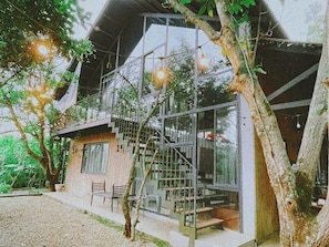 Ein modernes Haus mit einer Glaswendeltreppe, einer Bank und Lichterketten.