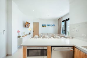 Een moderne keuken met een centraal eiland, een inbouwoven en een magnetron.