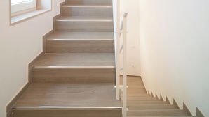 A staircase with wooden steps and a handrail, leading to a landing with a light fixture. - Le Contrade Vico Alba (Monopoli)