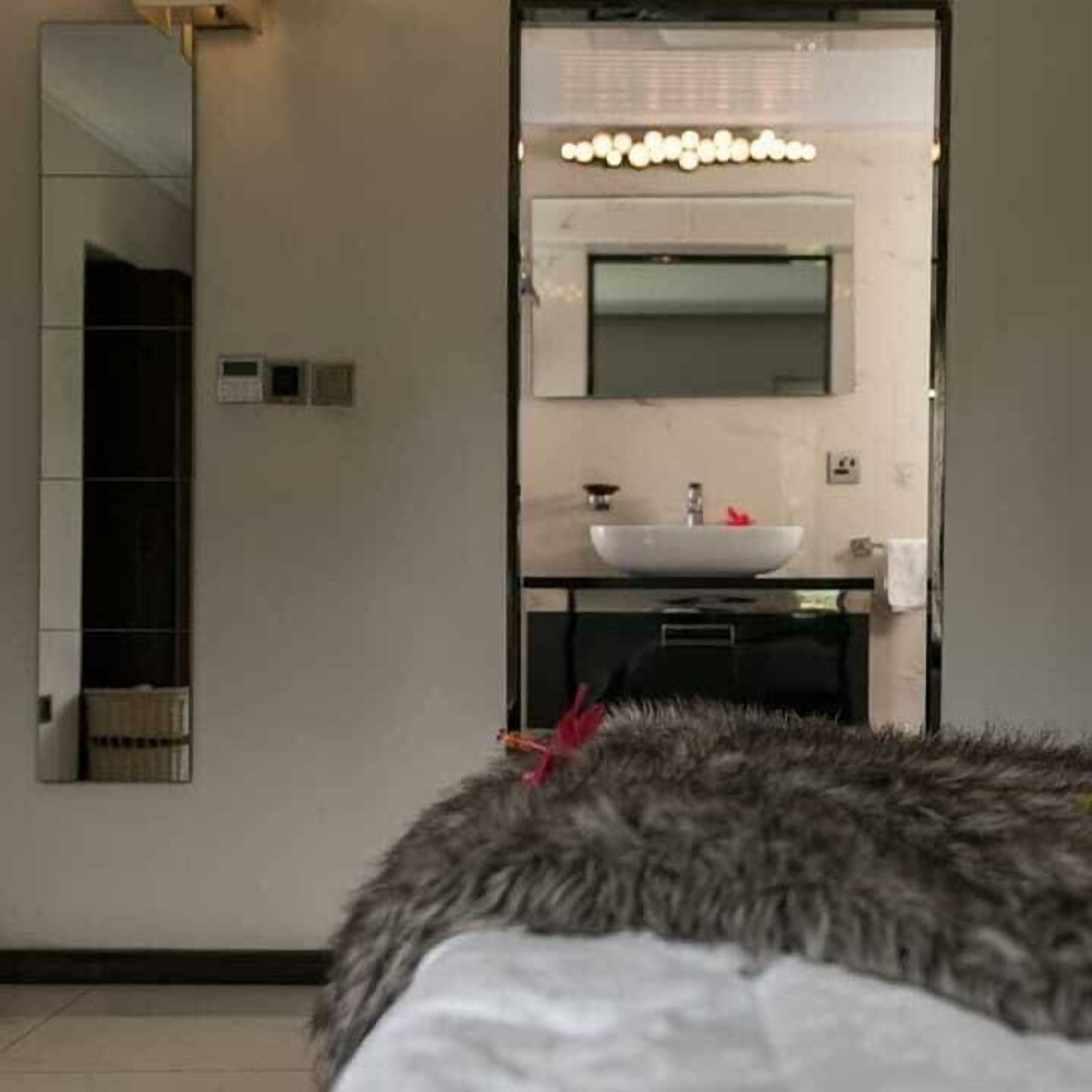 Een moderne badkamer met een grote spiegel, een wastafel en een badkamermeubel.