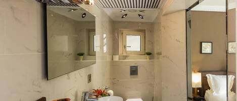 Ein kleines Hotelbad mit Waschbecken, Toilette und Spiegel.