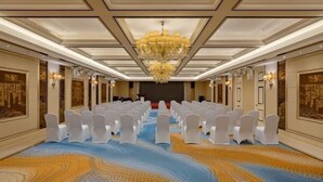 A conference room with rows of white chairs, a large chandelier, and patterned carpet. - Datong Hotel (Datong)