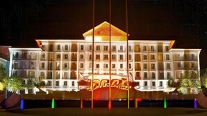 A multi-story hotel with a central atrium and a large illuminated sign.