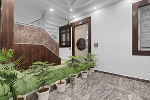A staircase with a wooden handrail and a patterned wall, leading to a door with a logo.