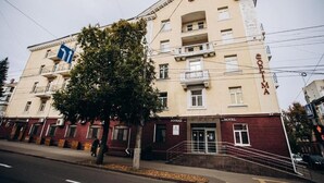 A multi-story building with a hotel sign, a staircase, and a tree in front. - Optima Collection Chernihiv (Chernihiv)