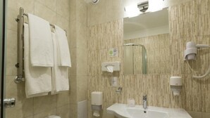 A bathroom with a sink, toilet, hand dryer, and towel rack.
