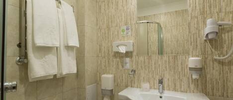 A bathroom with a sink, toilet, hand dryer, and towel rack.