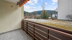 A balcony with a view of a snowy landscape and buildings in the distance.