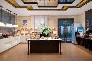 A hotel lobby with a reception desk, a coffee station, and a buffet area. - Days Inn by Wyndham Nanchang Donghu (Nanchang)